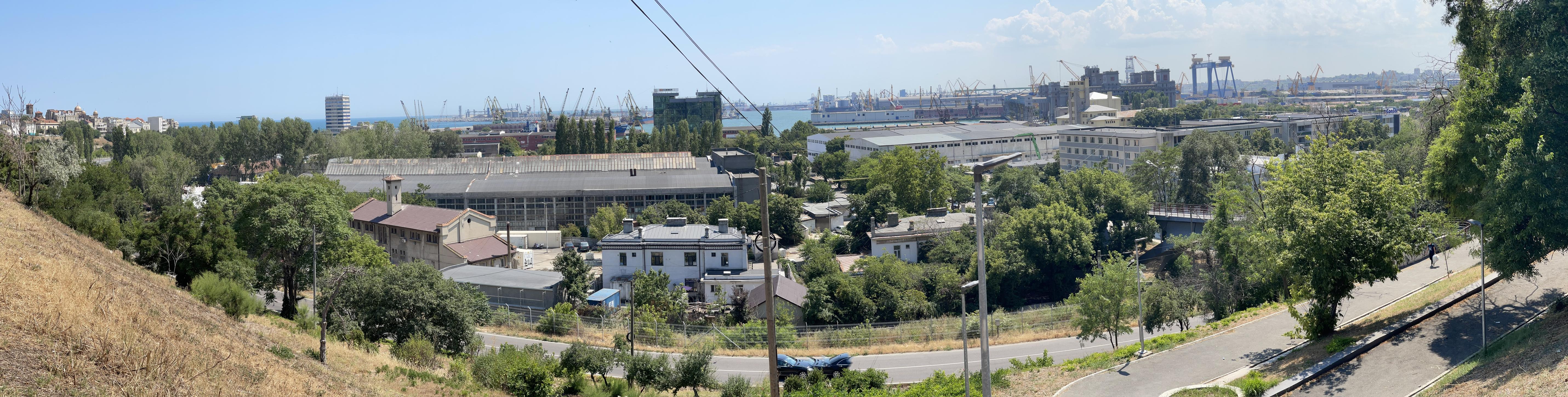 Panorama of the port of Constanța, many buildings and cranes, the Black Sea blue.